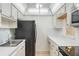 Well-maintained kitchen featuring white cabinetry and appliances, including a black refrigerator and white countertops at 5967 Terrace Park N Dr # 202, St Petersburg, FL 33709