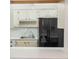 Practical kitchen view showcasing cabinetry, black refrigerator, and laundry area at 5967 Terrace Park N Dr # 202, St Petersburg, FL 33709