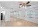 Open-concept living room with tiled floors, a ceiling fan, and a large mirror reflecting natural light at 5967 Terrace Park N Dr # 202, St Petersburg, FL 33709