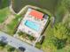 Aerial view of a relaxing community pool with lounge chairs, patio, and lush landscaping at 5967 Terrace Park N Dr # 202, St Petersburg, FL 33709