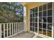 Outdoor balcony space with sliding glass doors, railing, and views of the surrounding trees at 6030 Printery St # 108, Tampa, FL 33616