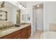 Bathroom with double sink vanity, granite counters, and tiled shower at 6030 Printery St # 108, Tampa, FL 33616