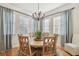 Charming dining room with a round wooden table, seating for six, a stylish chandelier, and natural light at 6030 Printery St # 108, Tampa, FL 33616
