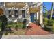 Charming home featuring a brick walkway leading to a blue front door, accented by awnings and lush landscaping at 6030 Printery St # 108, Tampa, FL 33616