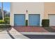 Two-car garage with blue doors and brick driveway at 6030 Printery St # 108, Tampa, FL 33616