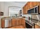 A modern kitchen featuring wood cabinets, stainless steel appliances, granite countertops, and hardwood floors at 6030 Printery St # 108, Tampa, FL 33616