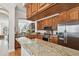 Modern kitchen featuring wood cabinets, stainless steel appliances, and a large granite countertop, perfect for cooking at 6030 Printery St # 108, Tampa, FL 33616