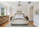 Bright and elegant main bedroom featuring a chandelier, natural light, and hardwood floors at 6030 Printery St # 108, Tampa, FL 33616