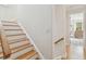 Staircase leading to a hardwood hallway with a view of a well-lit room at 6030 Printery St # 108, Tampa, FL 33616