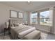 Serene main bedroom showcasing plush bedding, ample natural light, and minimalist decor at 6042 Golden Nettle Dr, Apollo Beach, FL 33572