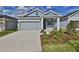 Attractive single-story home boasts a well-maintained lawn and inviting entry with beautiful plantings at 6042 Golden Nettle Dr, Apollo Beach, FL 33572