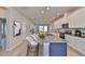 Modern kitchen with gray countertops, an island with bar stools and a view into the living room at 6042 Golden Nettle Dr, Apollo Beach, FL 33572