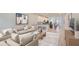 Bright, open-concept living room and kitchen with hardwood floors, a large sofa, and modern decor at 6042 Golden Nettle Dr, Apollo Beach, FL 33572