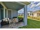 Cozy covered patio with outdoor seating and a view of the backyard and neighborhood at 6042 Golden Nettle Dr, Apollo Beach, FL 33572