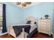 Bedroom features a cream-colored bed frame and chest of drawers paired with a ceiling fan at 6411 Mayra Shores Ln, Apollo Beach, FL 33572