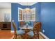Cozy dining area with stylish wooden chairs, a round glass table, and natural light from the window at 6411 Mayra Shores Ln, Apollo Beach, FL 33572