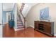 Charming entryway with a staircase adorned with decorative tiles, complemented by a stylish console table and hardwood floors at 6411 Mayra Shores Ln, Apollo Beach, FL 33572
