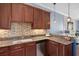 Efficient kitchen with granite countertops, stainless steel appliances, and tile backsplash, optimizing functionality and style at 6411 Mayra Shores Ln, Apollo Beach, FL 33572