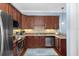 Modern kitchen with stainless steel appliances, dark wood cabinets, and tile backsplash, perfect for cooking and entertaining at 6411 Mayra Shores Ln, Apollo Beach, FL 33572