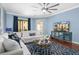 Bright living room with cozy seating, ceiling fan, and access to a balcony, perfect for relaxation and enjoying the view at 6411 Mayra Shores Ln, Apollo Beach, FL 33572