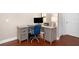 Home office with light gray desk and a comfortable blue office chair and dark wood flooring at 6411 Mayra Shores Ln, Apollo Beach, FL 33572