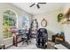 Bright home office featuring large windows, hardwood desk, massage chair, and ceiling fan at 7308 Carrington Oaks Ln, Apollo Beach, FL 33572