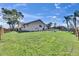 Spacious backyard features lush green lawn, mature trees, and a charming fence, perfect for outdoor activities at 811 Eagle Ln, Apollo Beach, FL 33572