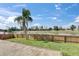A fenced backyard features a lush lawn, a pond view, and mature palm trees at 811 Eagle Ln, Apollo Beach, FL 33572