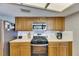 Kitchen with wooden cabinets, tile backsplash, stainless steel appliances, and bright overhead lighting at 811 Eagle Ln, Apollo Beach, FL 33572