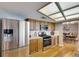 Well-lit kitchen with stainless steel appliances, wood cabinets and a view of the dining room at 811 Eagle Ln, Apollo Beach, FL 33572