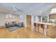 Open living space featuring wood floors, neutral paint, a ceiling fan, access to a kitchen and a gray sofa at 811 Eagle Ln, Apollo Beach, FL 33572