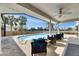 Relaxing backyard featuring a sparkling pool with comfortable lounge chairs and a ceiling fan for summer comfort at 811 Eagle Ln, Apollo Beach, FL 33572