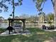 Grilling area near the lake with a stainless steel grill, picnic table, and peaceful views at 8158 Eagles Park N Dr, St Petersburg, FL 33709