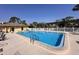Community pool with crystal clear water, ample lounge chairs, fenced perimeter and nearby pool house at 8158 Eagles Park N Dr, St Petersburg, FL 33709