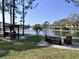 Community area with a BBQ grill and seating next to a scenic lake with fountain views and nearby buildings at 8158 Eagles Park N Dr, St Petersburg, FL 33709