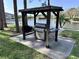 Outdoor BBQ grill under a wooden shelter with the lake and nearby buildings visible in the background at 8158 Eagles Park N Dr, St Petersburg, FL 33709