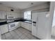 Bright kitchen with white appliances, ample cabinet space, and a tile floor at 8158 Eagles Park N Dr, St Petersburg, FL 33709