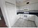 Well-lit kitchen featuring white appliances, tile flooring, and plenty of cabinets at 8158 Eagles Park N Dr, St Petersburg, FL 33709