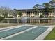 Shuffleboard courts located in front of a serene lake with a fountain and community buildings in the background at 8158 Eagles Park N Dr, St Petersburg, FL 33709