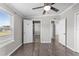 Bedroom featuring vinyl plank flooring, white trim, ceiling fan, and three entryways at 8428 Highland Pines Ct, Plant City, FL 33565