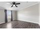 A spacious bedroom featuring gray vinyl floors, a modern ceiling fan, and a large window at 8428 Highland Pines Ct, Plant City, FL 33565