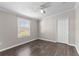 Bedroom with wood-look flooring, ceiling fan, closet, and large window with blinds at 8428 Highland Pines Ct, Plant City, FL 33565