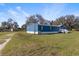 A blue mobile home sits on a large grassy lot with a storage shed on the property at 8428 Highland Pines Ct, Plant City, FL 33565