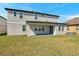 Back exterior of home with a covered patio, gray paint, well maintained lawn, and nearby air conditioning unit at 8816 Mugnai St, Riverview, FL 33578