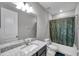 Bathroom features granite vanity, shower with curtain, and matching neutral decor at 8816 Mugnai St, Riverview, FL 33578
