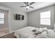 Well-lit bedroom with a ceiling fan, large window, and mounted TV for comfortable living at 8816 Mugnai St, Riverview, FL 33578