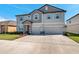 Two story home with a two car garage, light gray paint, stone entryway and shutters on the windows at 8816 Mugnai St, Riverview, FL 33578