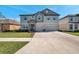 Two story home with a two car garage, light gray paint, stone entryway and shutters on the windows at 8816 Mugnai St, Riverview, FL 33578