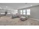 Open-concept living room with sectional sofa and views into the modern kitchen at 8816 Mugnai St, Riverview, FL 33578