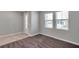 Open living room with gray carpet, two large windows, and white trim, door, and baseboards at 8816 Mugnai St, Riverview, FL 33578